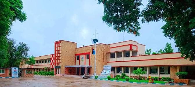 The main building of Cadet College Petaro, with the college crest over the entrance and the national flag flying above.